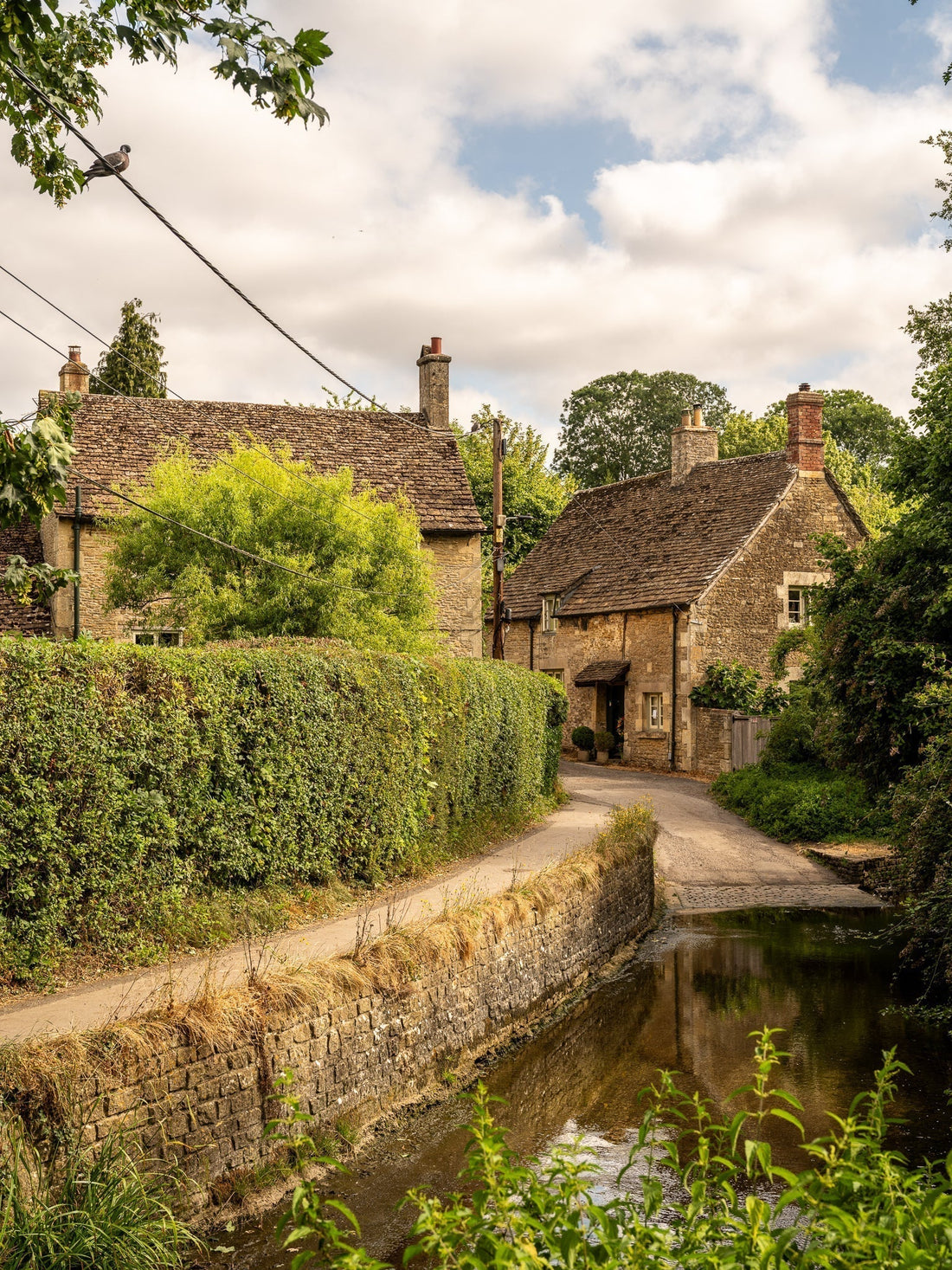 Footpath alongside a stream and cottage in Lacock, a Cotswolds village